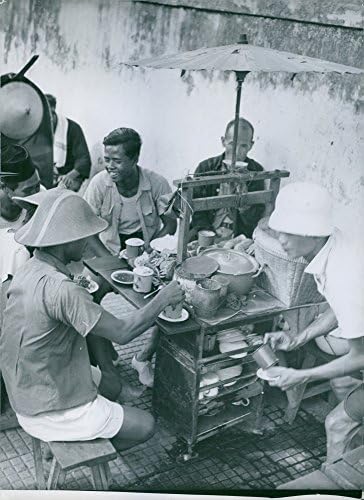 צילום וינטג 'של לקוחות אוכלים בעגלת אוכל קטנה בעיירה באינדונזיה.